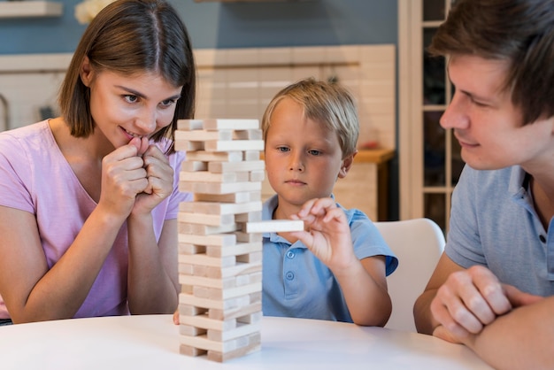 Portrait de parents jouant jenga avec fils