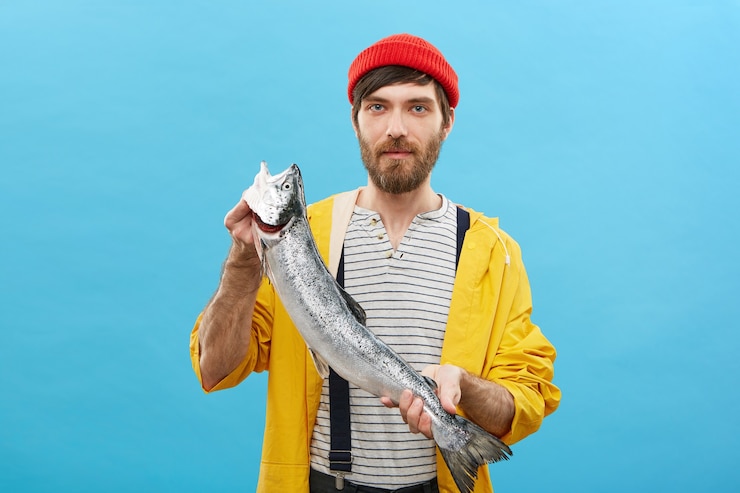 Photo gratuit portrait de pêcheur barbu debout avec d'énormes poissons