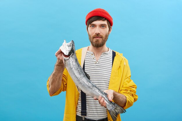 Portrait de pêcheur barbu debout avec d'énormes poissons