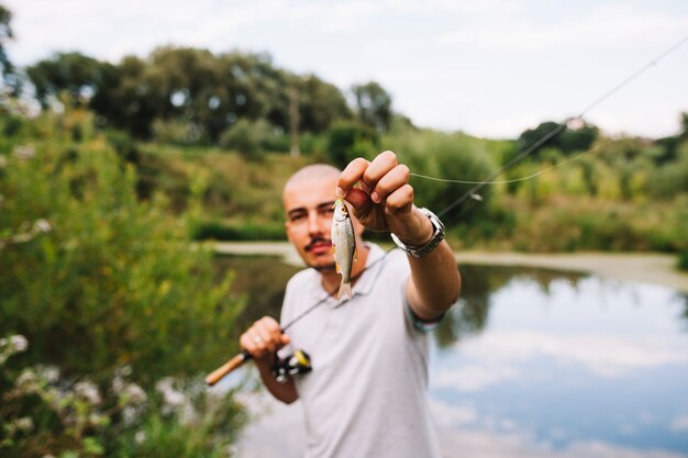 Portrait, de, a, pêcheur, tenue, poisson frais, contre, lac