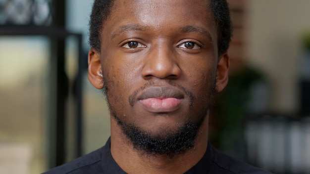 Portrait d'une personne afro-américaine souriante et regardant la caméra, exprimant le bonheur et les émotions positives. Jeune homme avec un sourire authentique et des dents blanches se sentant heureux et joyeux.