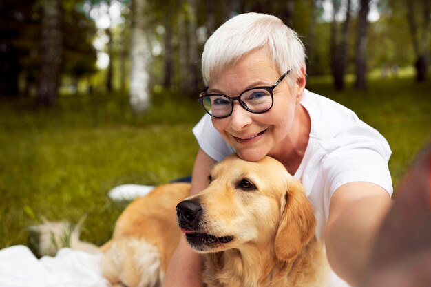 Portrait d'une personne âgée prenant un selfie avec son chien