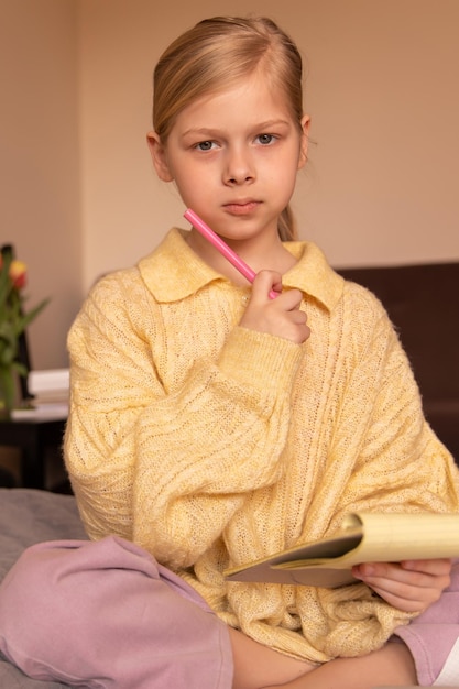 Portrait de petit enfant regarde la caméra avec des cahiers