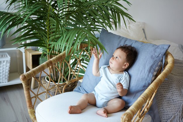 Un portrait d'un petit garçon assis sur la chaise