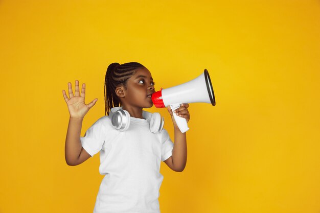 Portrait de petite fille afro-américaine isolé sur studio jaune