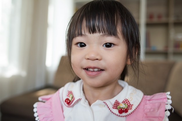 Portrait de petite fille asiatique jouant dans sa maison