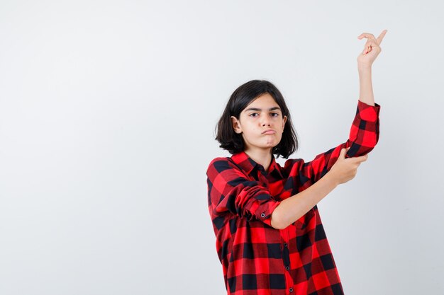 Portrait d'une petite fille belle pointant vers le haut