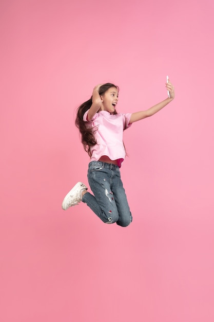 Portrait de petite fille caucasienne isolé sur studio rose, concept d'émotions