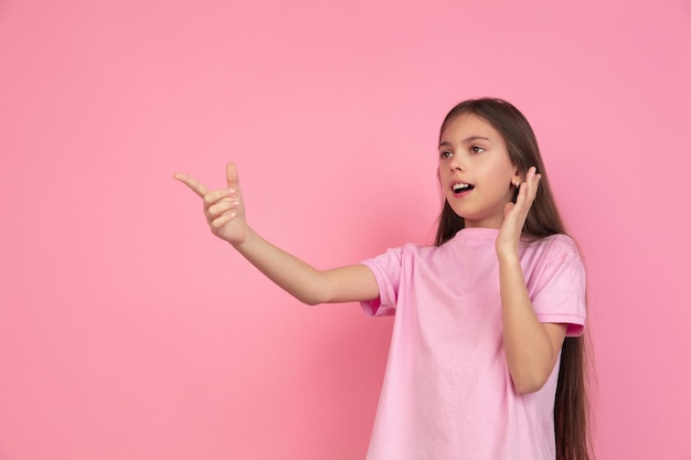 Portrait de petite fille caucasienne isolé sur studio rose, concept d'émotions