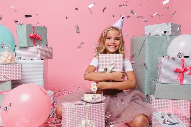 Portrait d'une petite fille dans un chapeau d'anniversaire célébrant