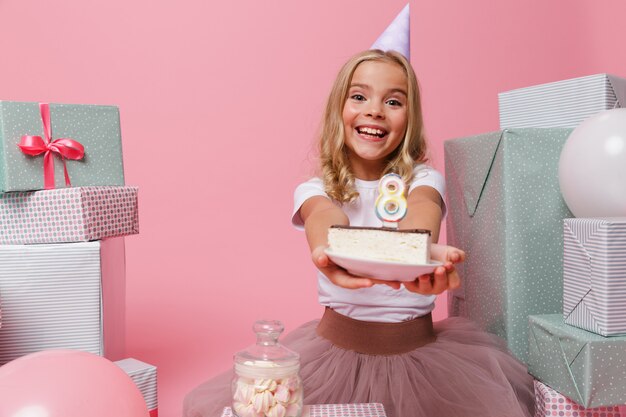 Portrait d'une petite fille excitée dans un chapeau d'anniversaire