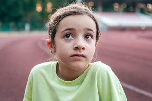 Photo gratuite portrait d'une petite fille fatiguée au stade