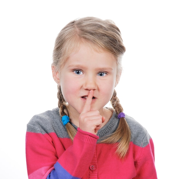 Portrait de petite fille avec un geste de silence sur l'espace blanc