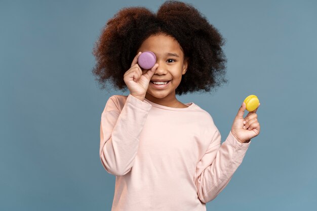 Portrait de petite fille mignonne avec des macarons