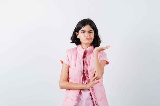 Portrait d'une petite fille en t-shirt blanc et gilet matelassé