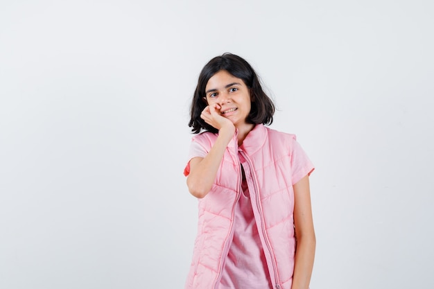 Portrait d'une petite fille en t-shirt blanc et gilet matelassé