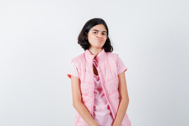 Portrait d'une petite fille en t-shirt blanc et gilet matelassé