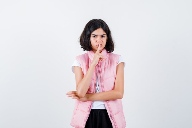 Portrait d'une petite fille en t-shirt blanc et gilet matelassé