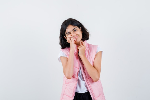 Portrait d'une petite fille en t-shirt blanc et gilet matelassé