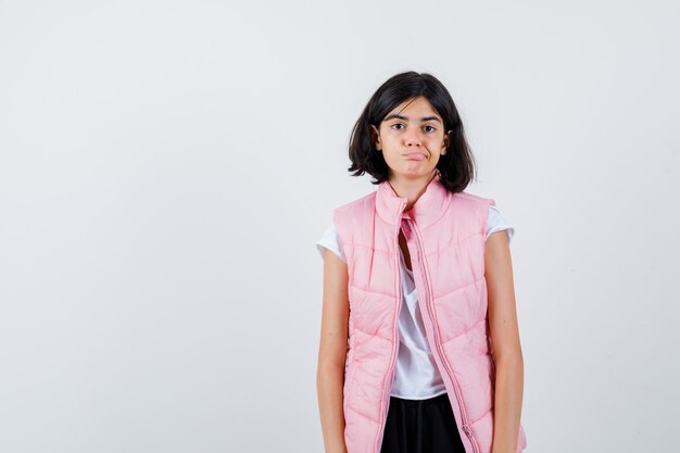 Portrait d'une petite fille en t-shirt blanc et gilet matelassé