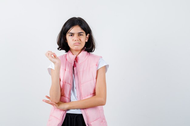 Portrait d'une petite fille en t-shirt blanc et gilet matelassé