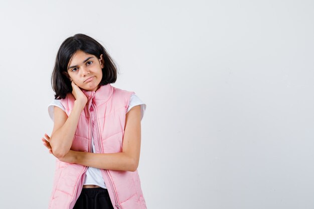 Portrait d'une petite fille en t-shirt blanc et gilet matelassé