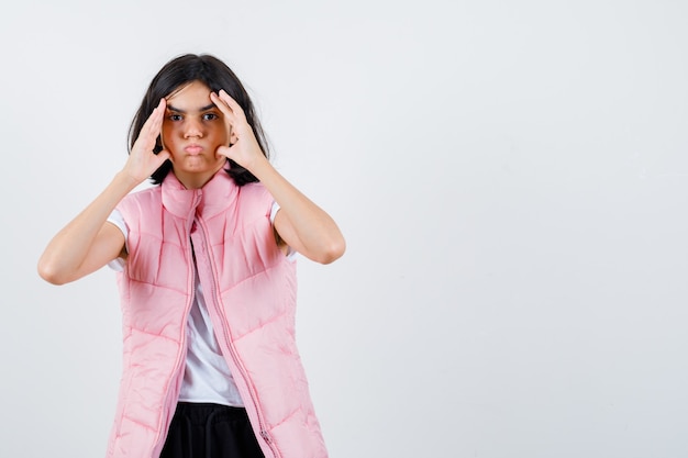 Portrait d'une petite fille en t-shirt blanc et gilet matelassé