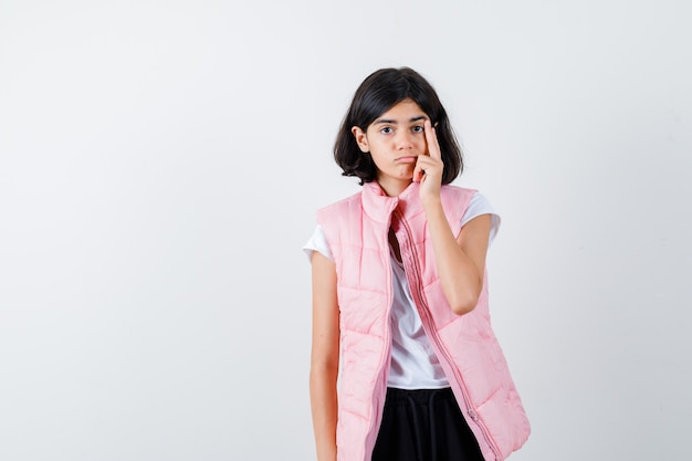 Portrait d'une petite fille en t-shirt blanc et gilet matelassé