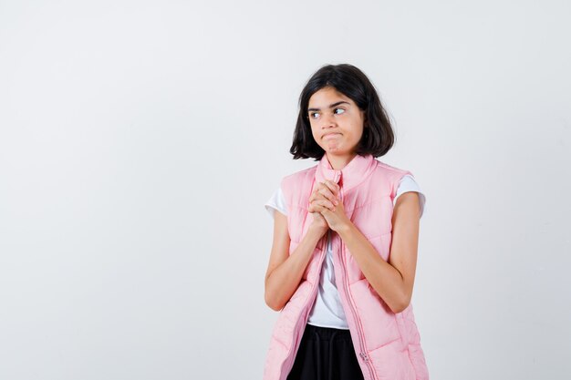 Portrait d'une petite fille en t-shirt blanc et gilet matelassé