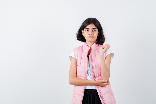 Portrait d'une petite fille en t-shirt blanc et gilet matelassé