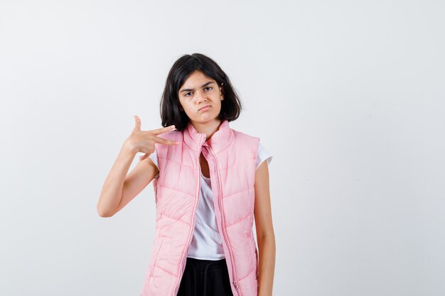 Portrait d'une petite fille en t-shirt blanc et gilet matelassé