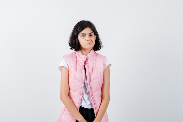 Portrait d'une petite fille en t-shirt blanc et gilet matelassé