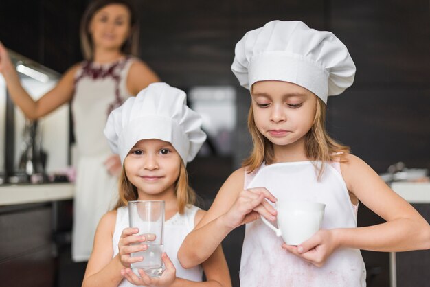 Portrait, de, petites filles, porter, chapeau chef, tenant verre, et, tasse