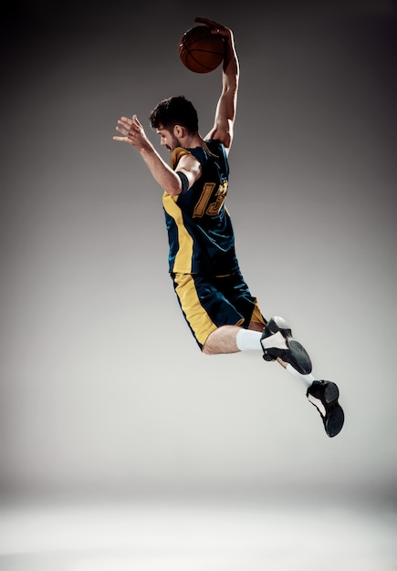 Portrait en pied d'un basketteur avec ballon
