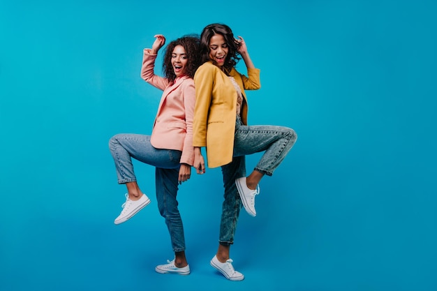 Portrait en pied de deux filles debout sur une jambe Prise de vue en studio de dames américaines