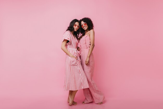 Portrait en pied de magnifiques dames en vêtements d'été souriant. Beaux modèles féminins en tenue lumineuse posant.