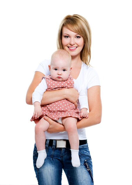 Portrait en pied d'une mère souriante avec bébé sur les mains - isolé sur blanc