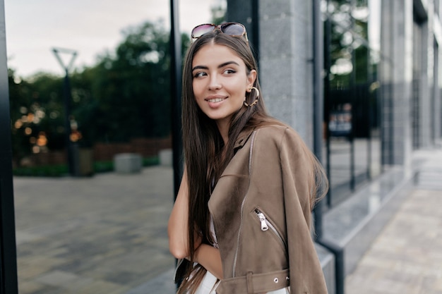 Photo gratuite portrait en plein air de belle jolie femme avec de longs cheveux noirs et un sourire merveilleux passer du temps libre dans le parc et attendre des amis