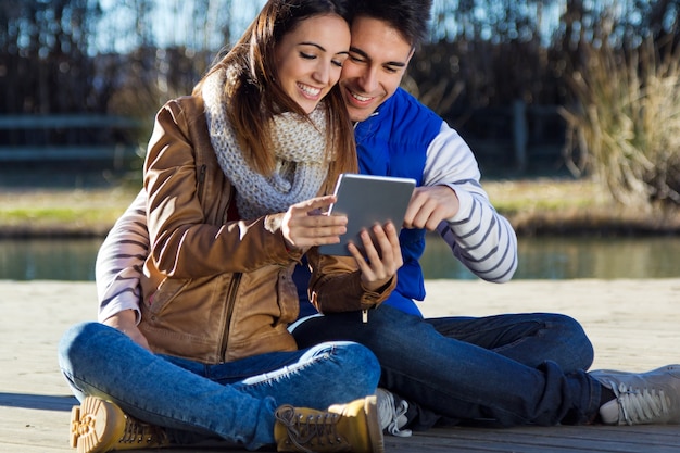 Portrait en plein air de jeune couple avec tablette numérique