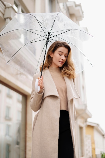 Portrait de pluie de belle jeune femme avec parapluie