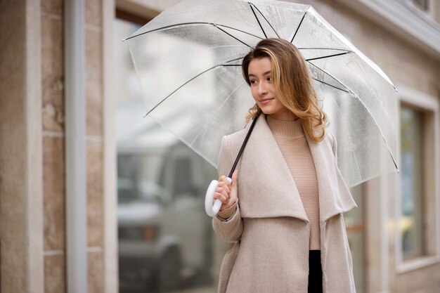 Portrait de pluie de belle jeune femme avec parapluie