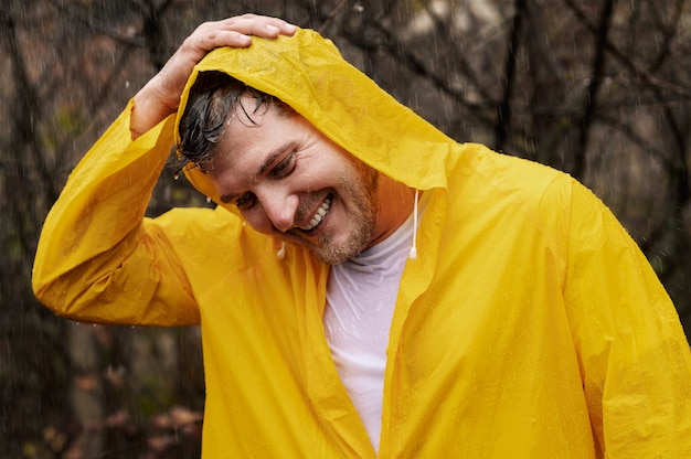 Portrait de pluie de jeune homme en manteau de pluie