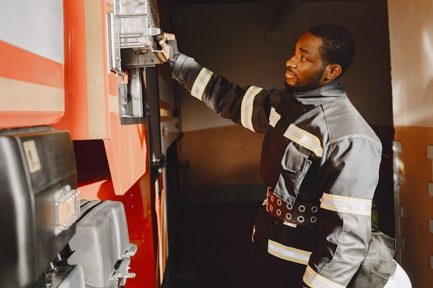 Portrait d'un pompier debout devant un camion de pompiers