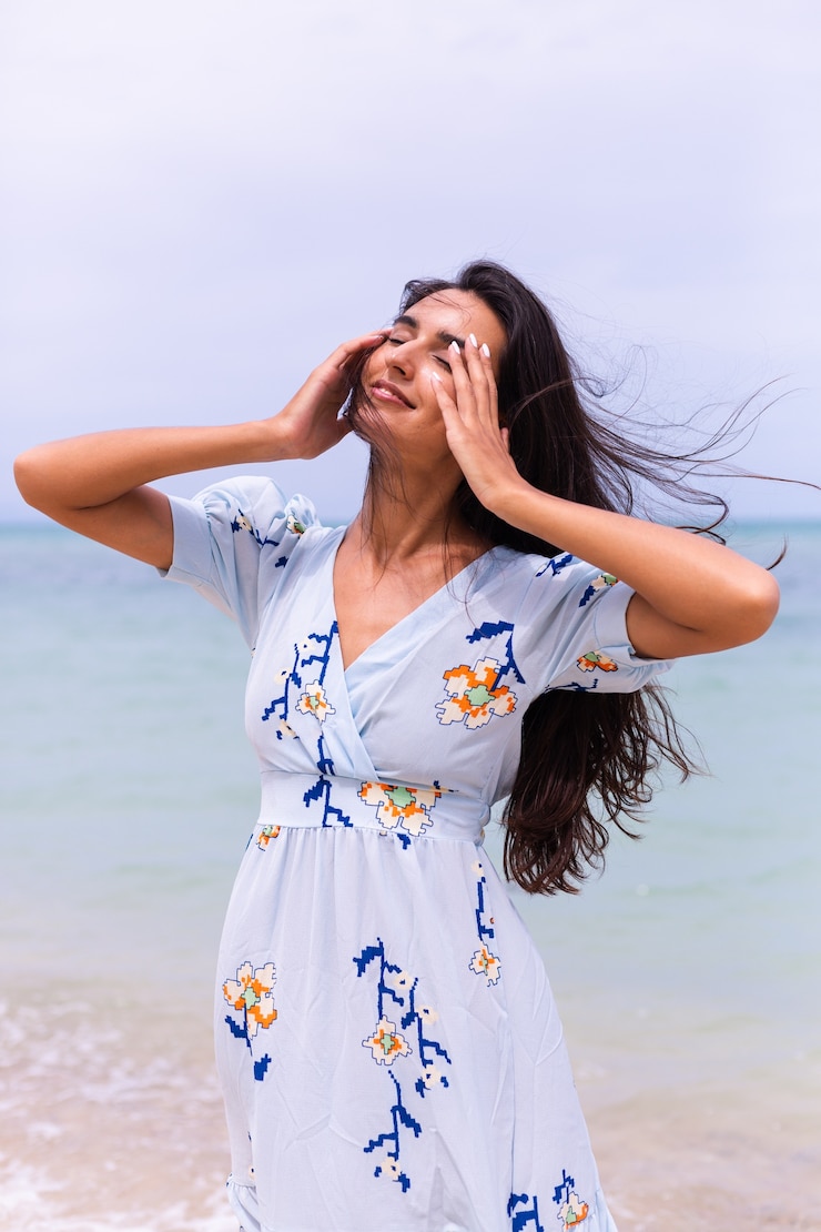 Photo gratuit portrait romantique de femme en longue robe bleue sur la plage au bord de la mer au jour venteux