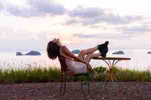 Photo gratuite portrait romantique de jeune femme caucasienne en robe d'été profitant de la détente dans le parc sur la montagne avec une vue imprenable sur la mer tropicale