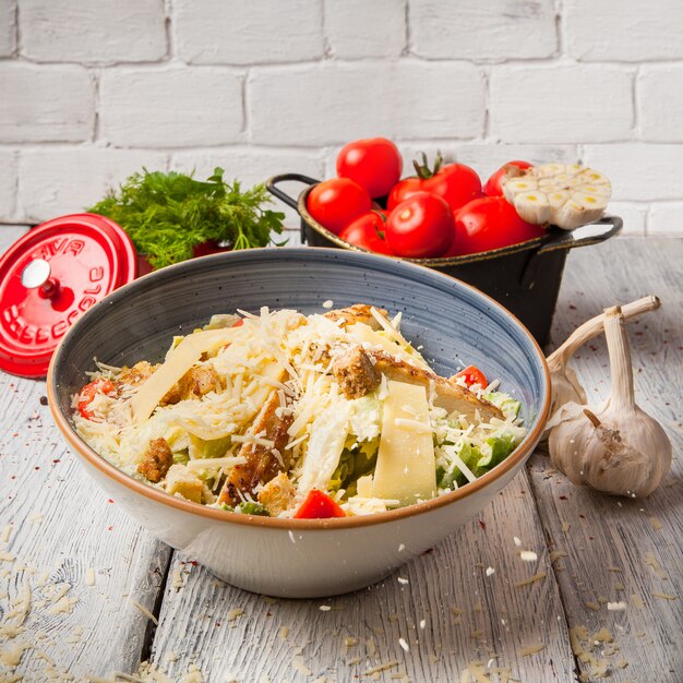 Portrait de salade de poulet dans un bol avec de l'ail et des tomates fraîches