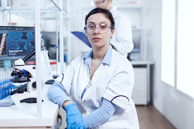 Portrait d'un scientifique à succès dans un laboratoire de microbiologie portant un équipement de protection. chimiste portant une blouse de laboratoire utilisant la technologie moderne lors d'une expérience scientifique dans un environnement stérile.