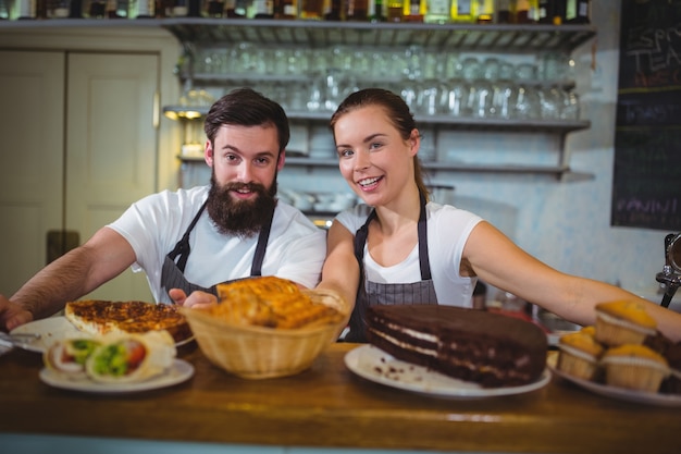 Portrait de serveur et serveuse debout au comptoir