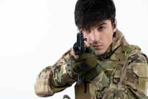 Photo gratuite portrait de soldat masculin en uniforme militaire avec mur blanc de mitrailleuse