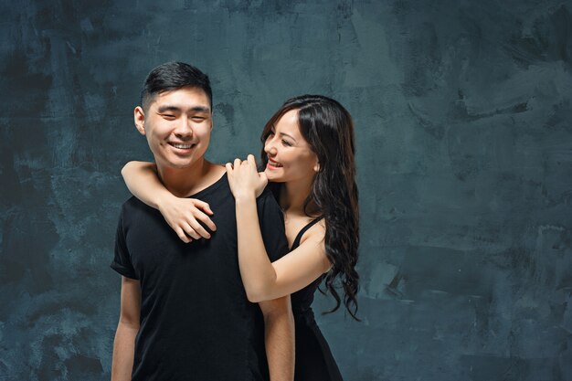 Portrait de souriant couple coréen sur un gris